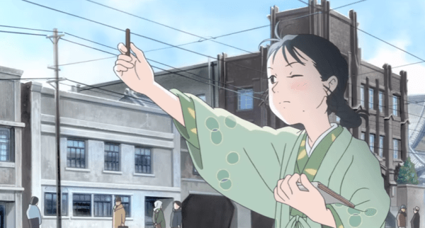 A girl in a kimono closes one eye and holds out a piece of charcoal, like an artist imagining a snapshot