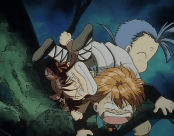Three chibi figures are piled awkwardly atop each other in a tree: On top is a man with flyaway bangs and smiling eyes wearing a tunic; below him is a girl with her hair in two buns, teeth gritted and eyes squinted; and at the bottom of the pile is a redhead in a dark jacket, looking below him with a wide-mouthed look of shock