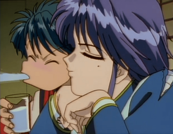 A close shot of a purple-haired androgynous person leaning their chin against their hands, eyes closed and expression calm. Behind them, a young man spits out his drink.