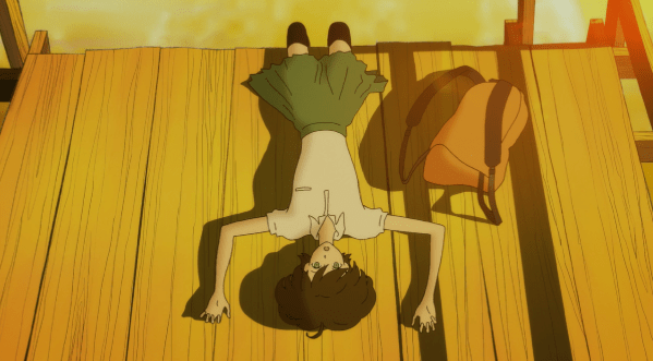 A teen girl in a school uniform lies on her back on the edge of a dock at sunset, arms spread to either side of her face.