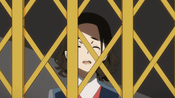 A teen girl in a school uniform smiles weakly behind an old-fashioned elevator gate.