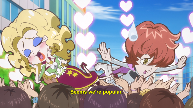 A tiny woman with curly blonde hair wearing a full-length skirt and a tiny man with messy brown hair wearing a short cape (Litz and Chopin) are crowd-surfing, with hearts bursts around them. Subtitles read: "Seems we're popular."